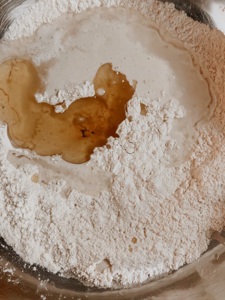 Sourdough starter, flour, oil, and salt in a bowl ready to be mixed