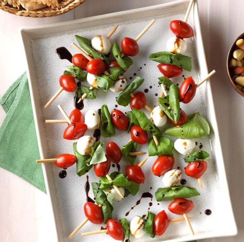 Cherry Tomatoes, Fresh Mozzarella Balls, and basil on a skewer dotted with balsamic vinegar