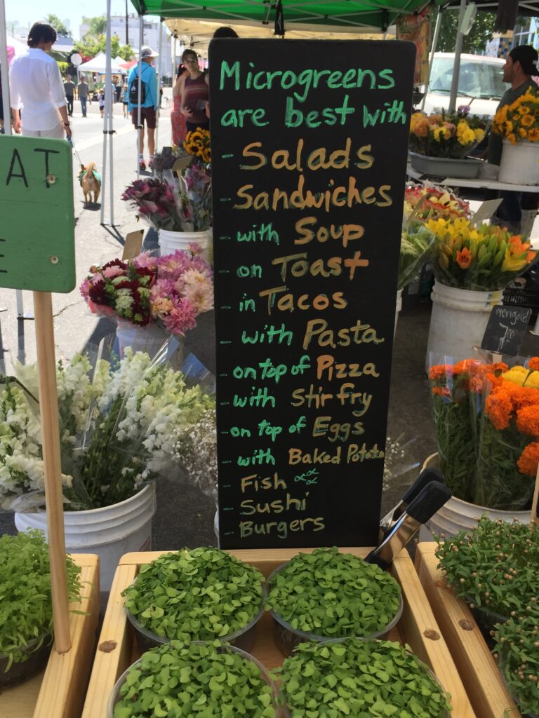 Sign suggesting ways to eat microgreens displayed in our farmers market booth